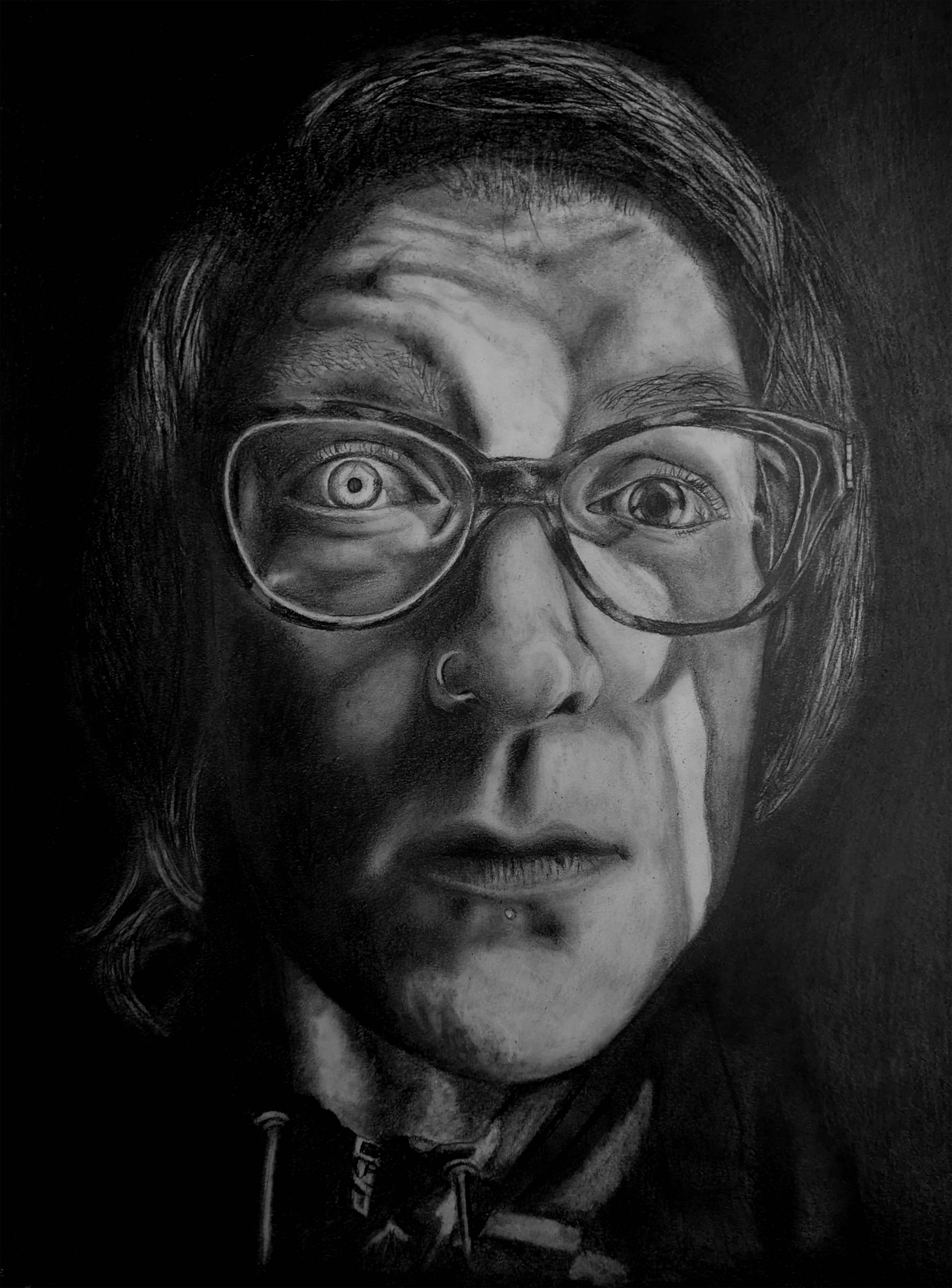 A picture of a woman who looks surprised and has a ray of light on her face running vertically from her forehead to the bottom of her cheek. One eye in the light and is a light color, one eye is dark because it is in the shadows. The background is black and the woman is wearing dark glasses.